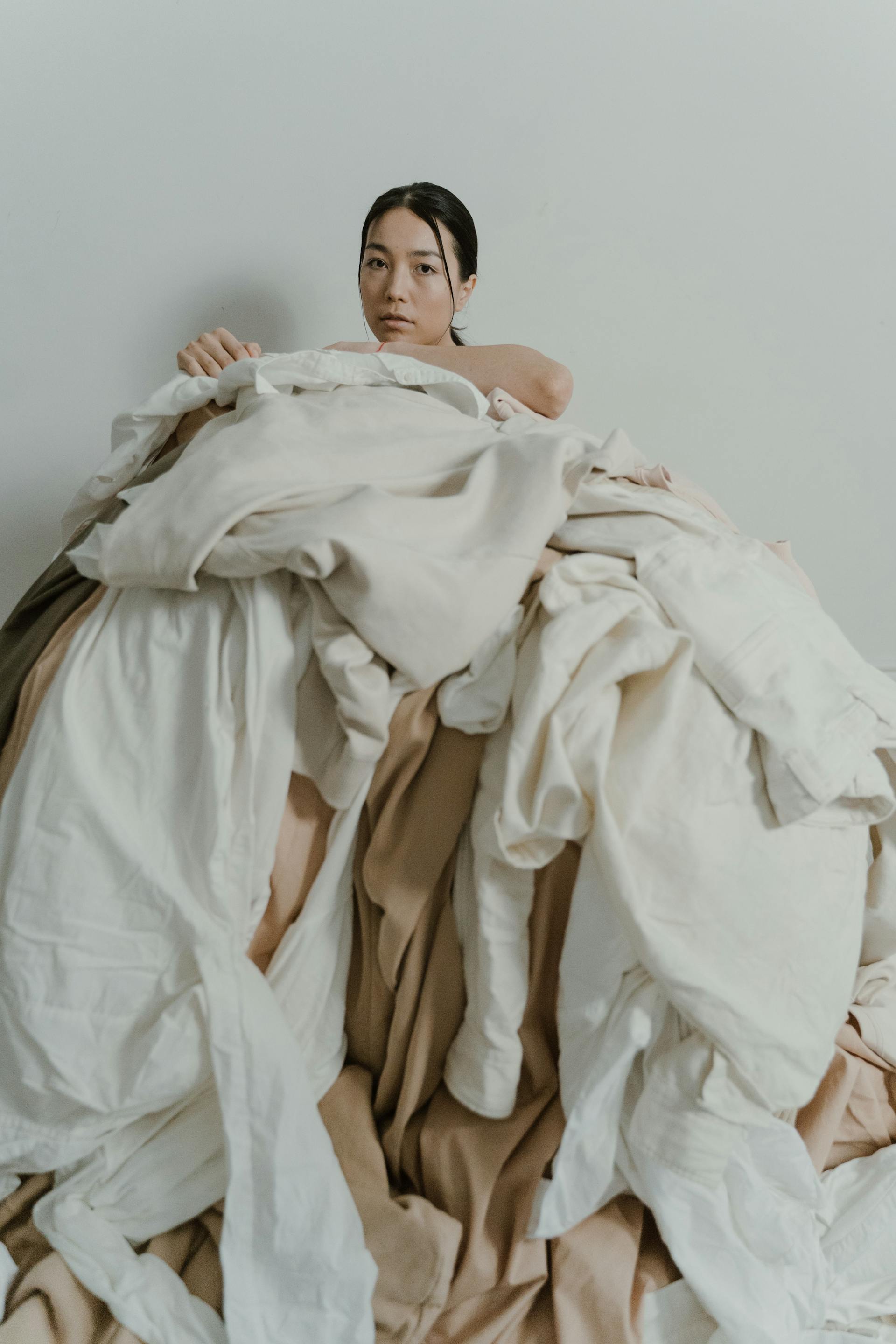 Large pile of discarded clothing in landfill context