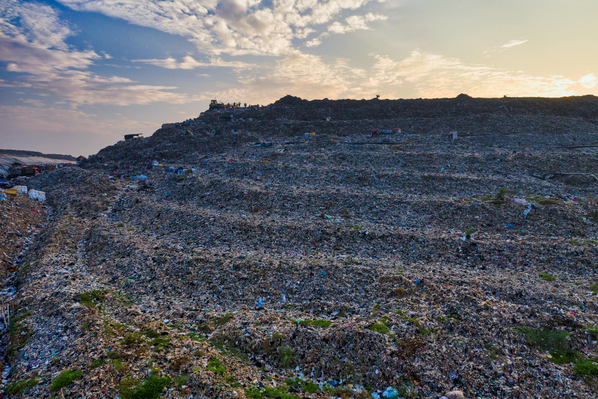 Mountains of discarded textile waste at an industrial landfill — the hidden destination of fast fashion